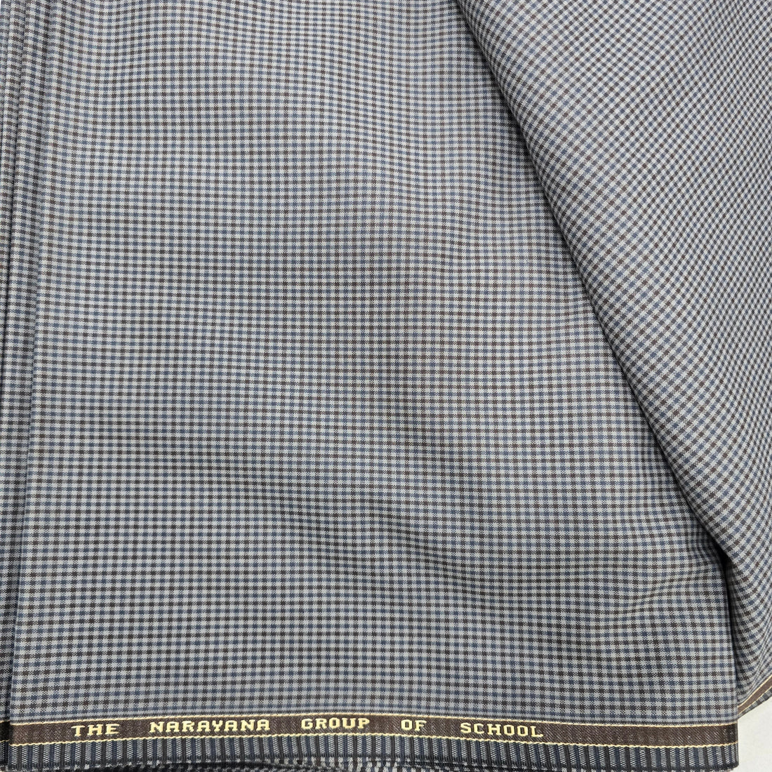 Ambika Stores blue and brown checked suiting fabric for Narayana school uniforms. Durable blend for blazers, trousers, skirts.