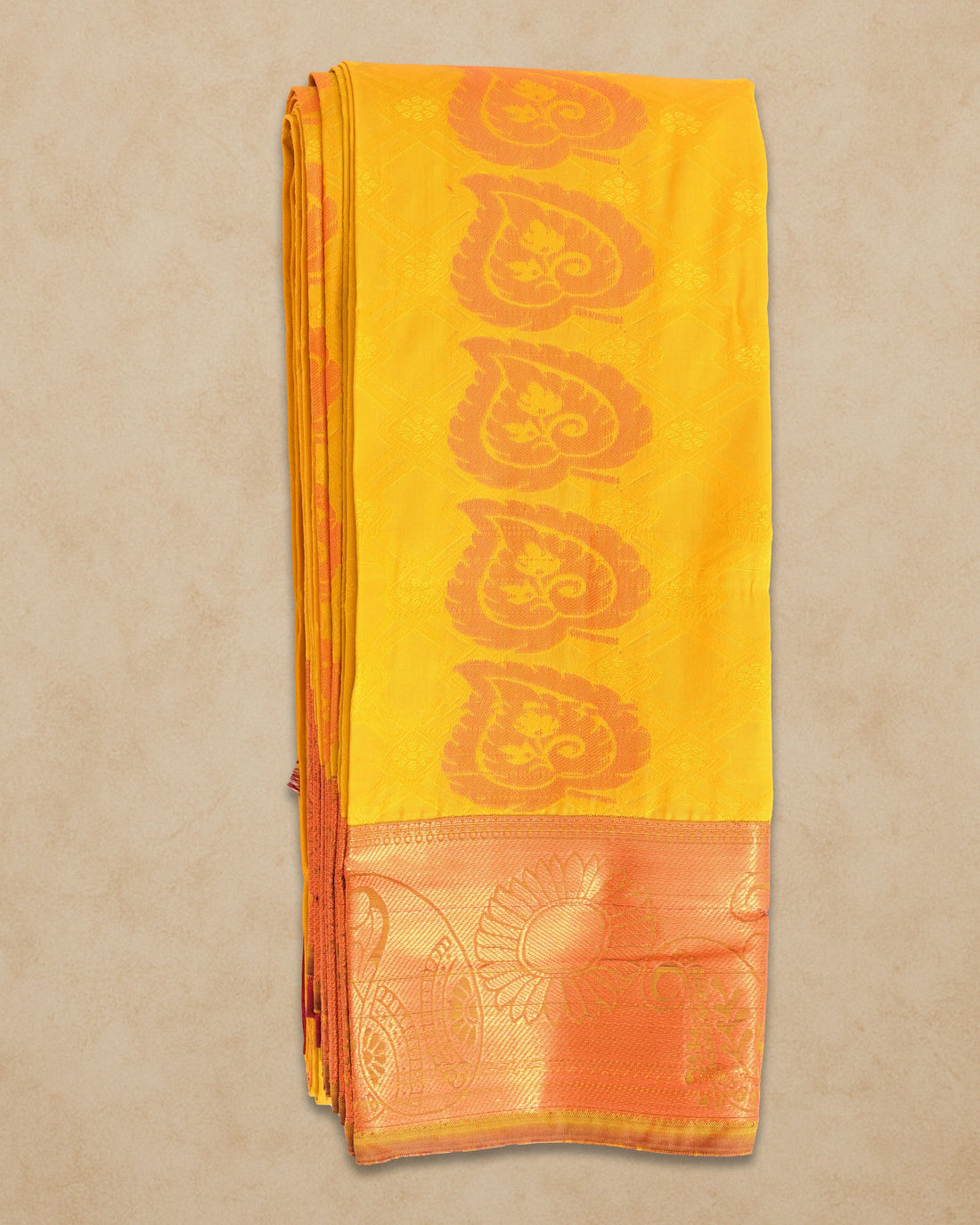 Ambika Stores mango yellow silk saree with orange paisley border and woven diamond pattern. Ideal for festive occasions.