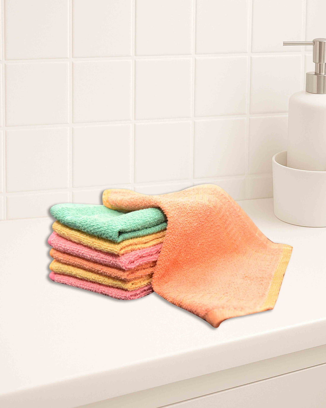 Ambika Stores multicolor 10x10 inch cotton hand towels stacked on a white bathroom counter.