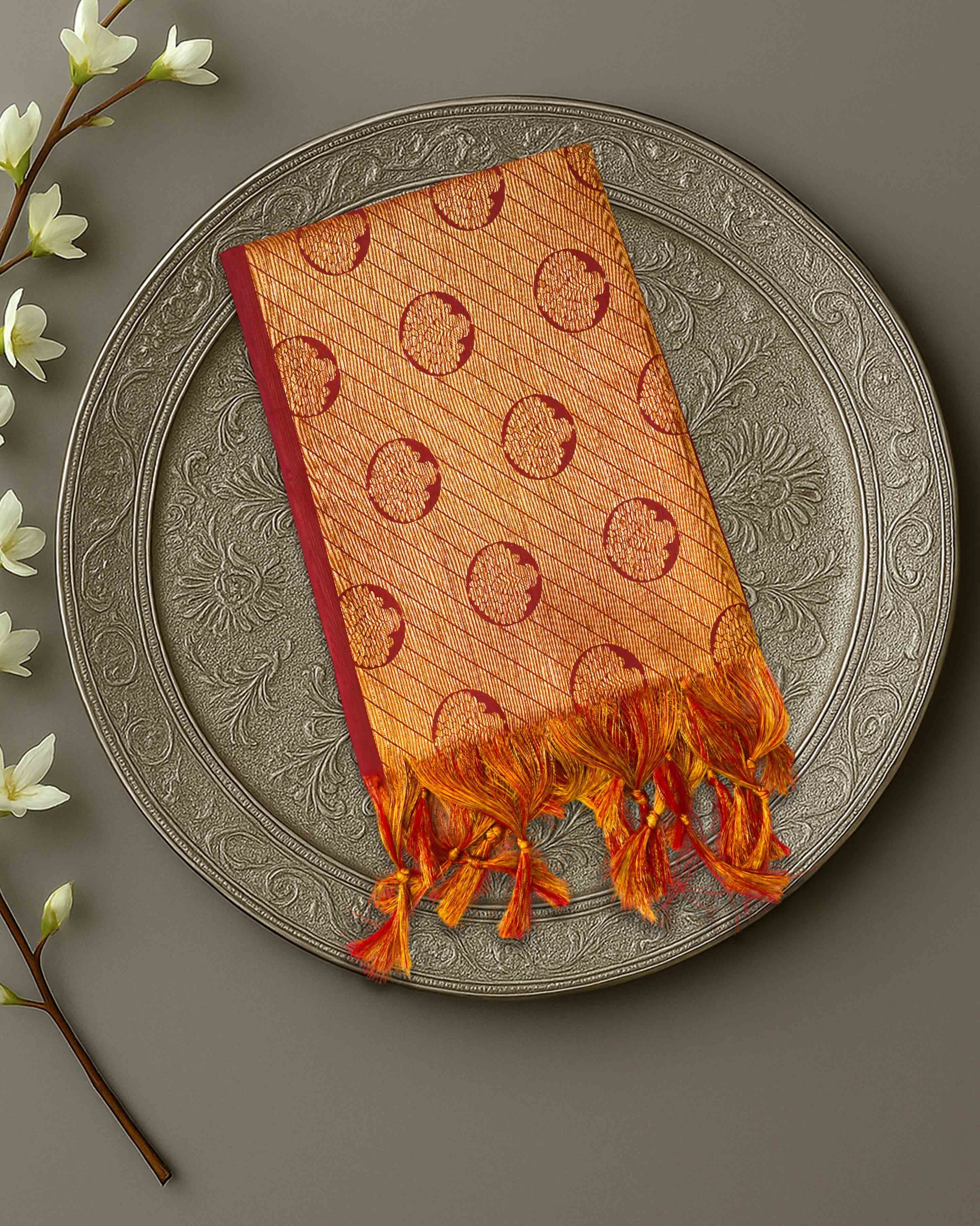 Ambika Stores premium orange and gold zari Ponnadai shawl with traditional circular motifs and tassel fringe.