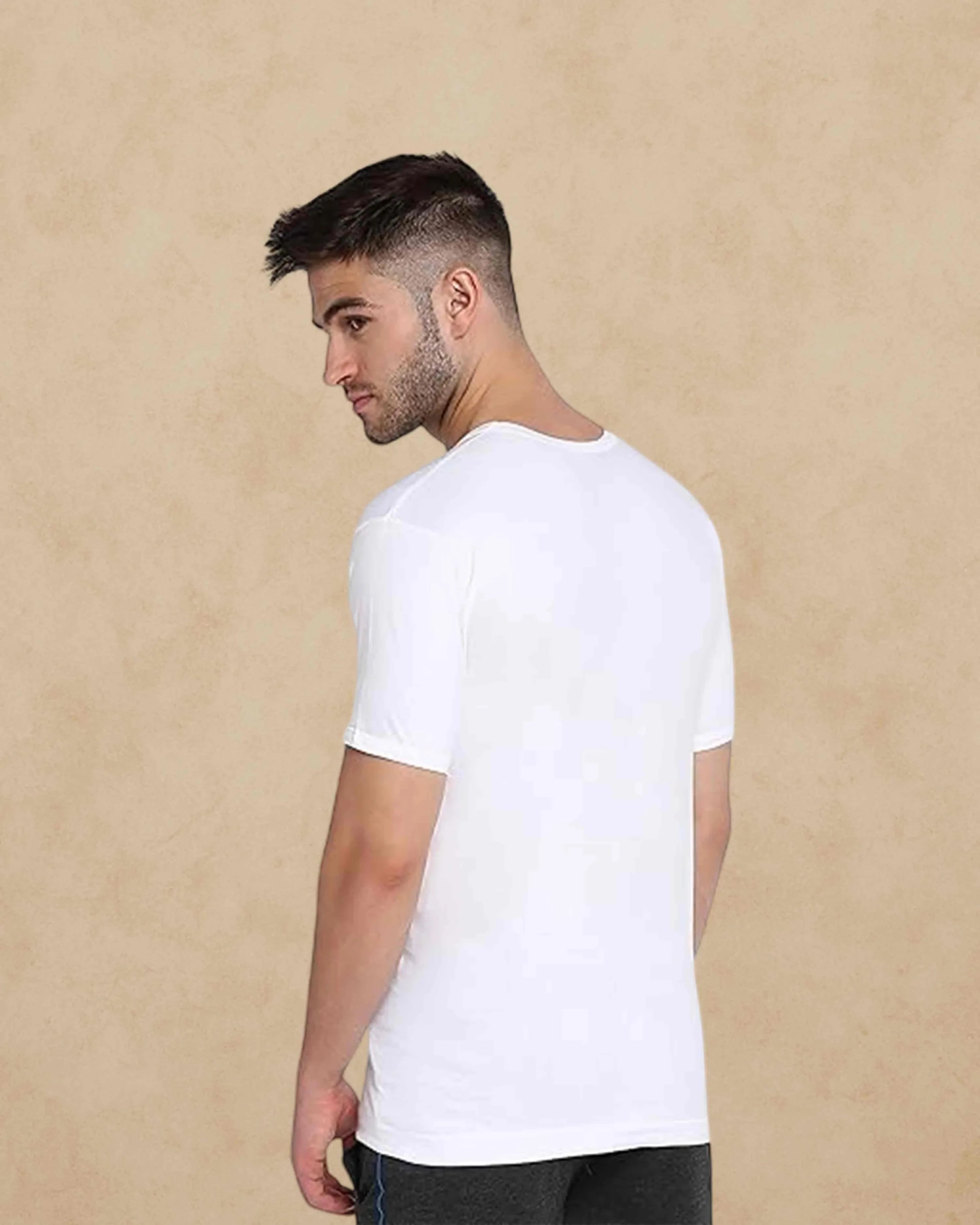 Ambika Stores Poomer white cotton half sleeve vest worn by a man, showing a comfortable round neck fit.