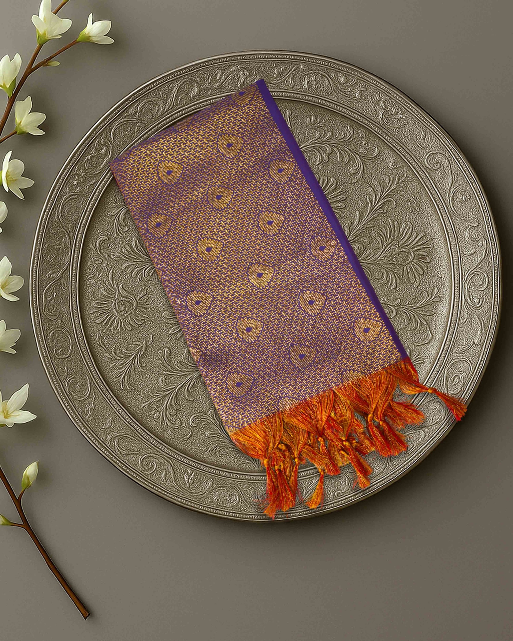 Ambika Stores purple and gold zari Ponnadai shawl with orange tassels, displayed on an ornate silver plate.