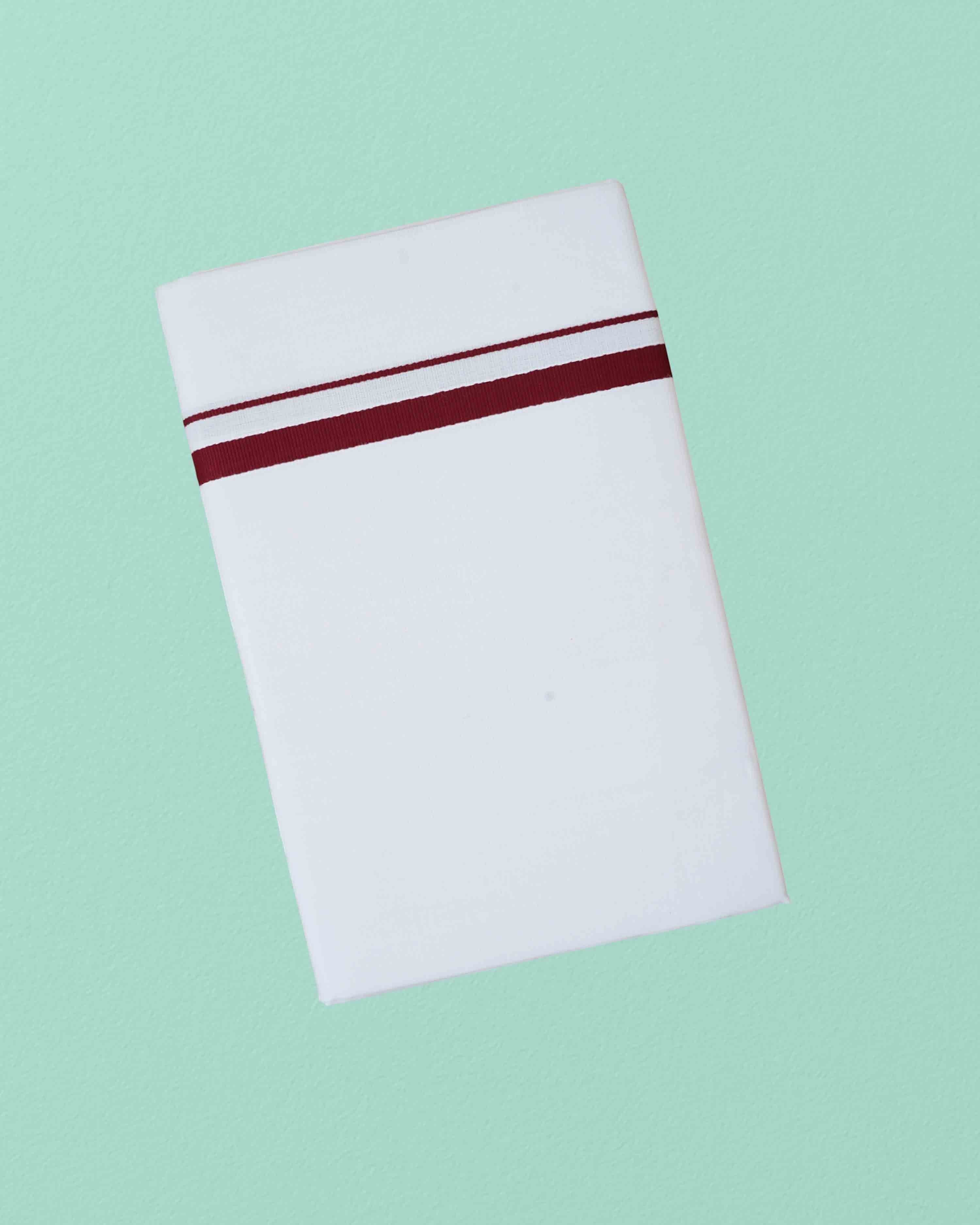 Ambika Stores white cotton dhoti with a single maroon border for traditional ceremonies and daily wear.
