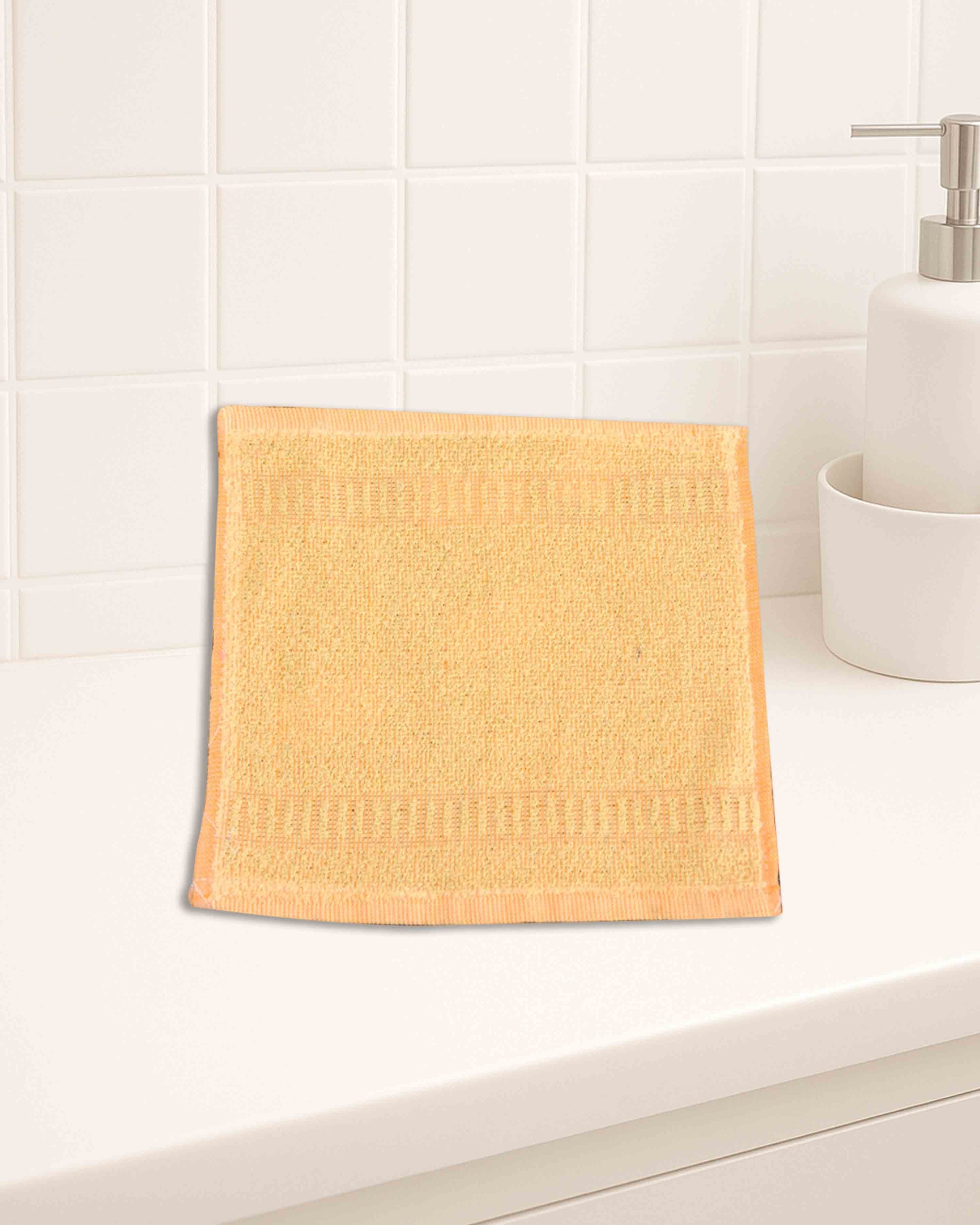 Ambika Stores 10x10 inch yellow cotton hand towel with textured border on a white bathroom counter