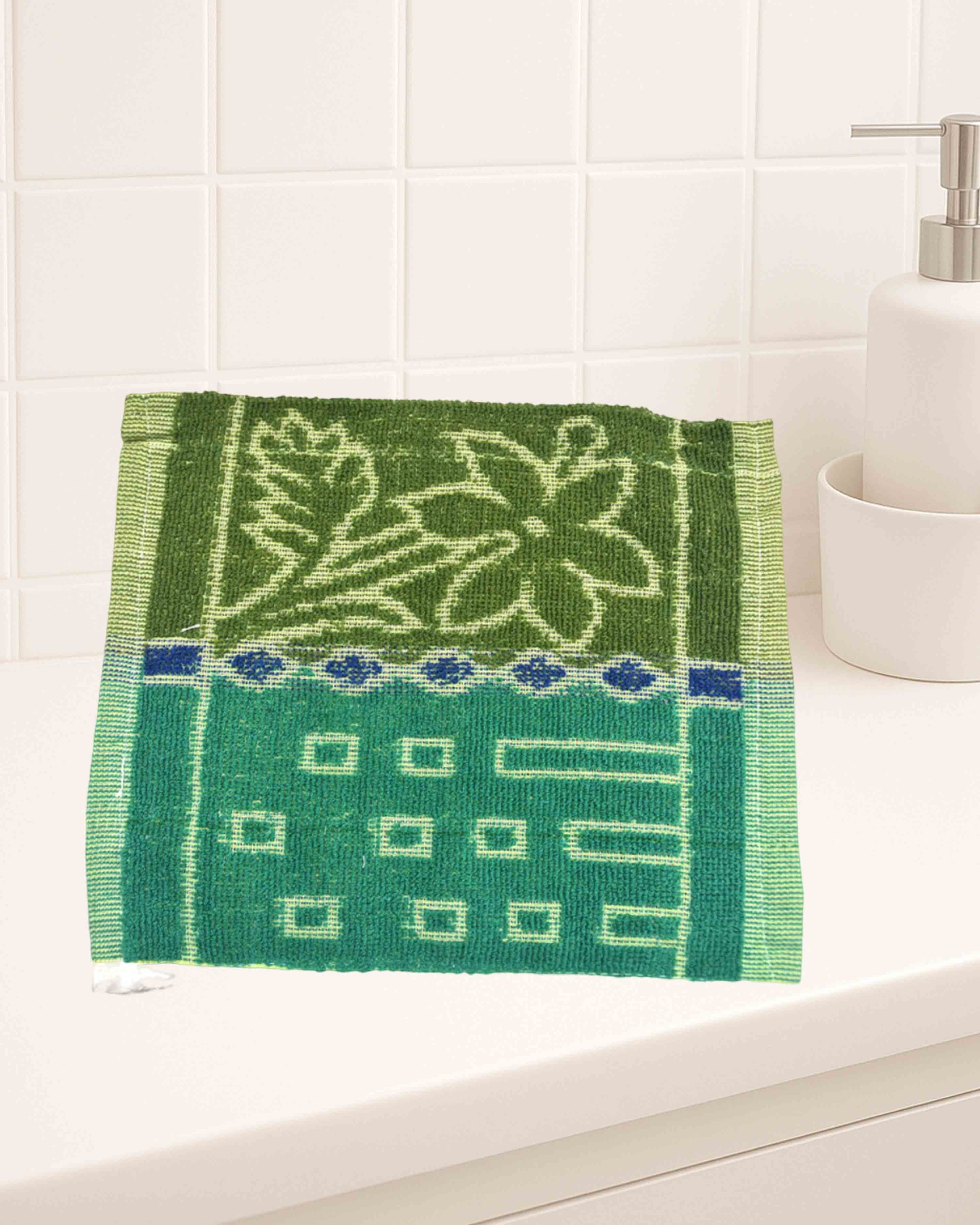 Ambika Stores cotton hand towel featuring a green floral and geometric pattern on a bathroom vanity.