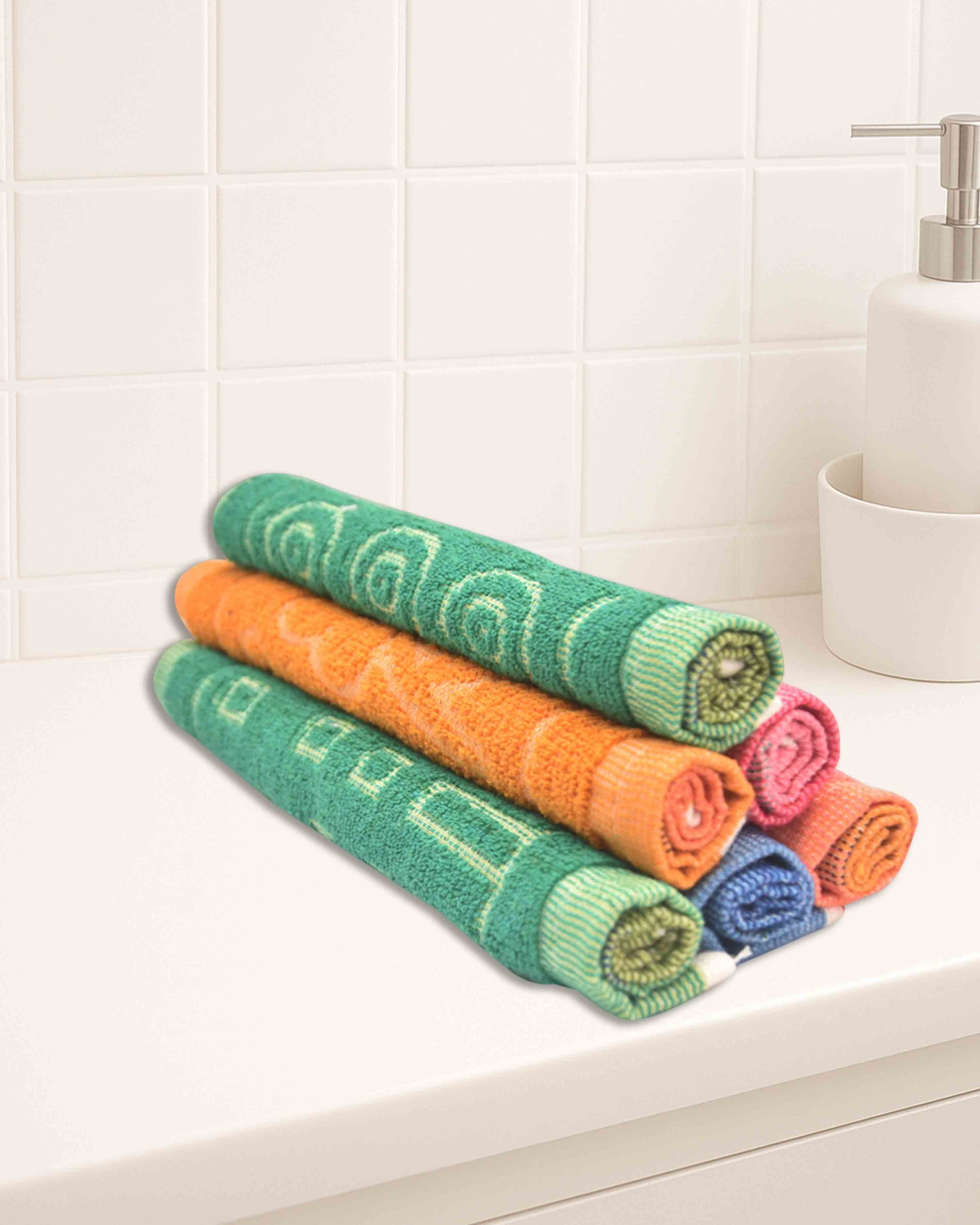 Ambika Stores set of rolled colorful cotton washcloths with geometric patterns on a white bathroom vanity