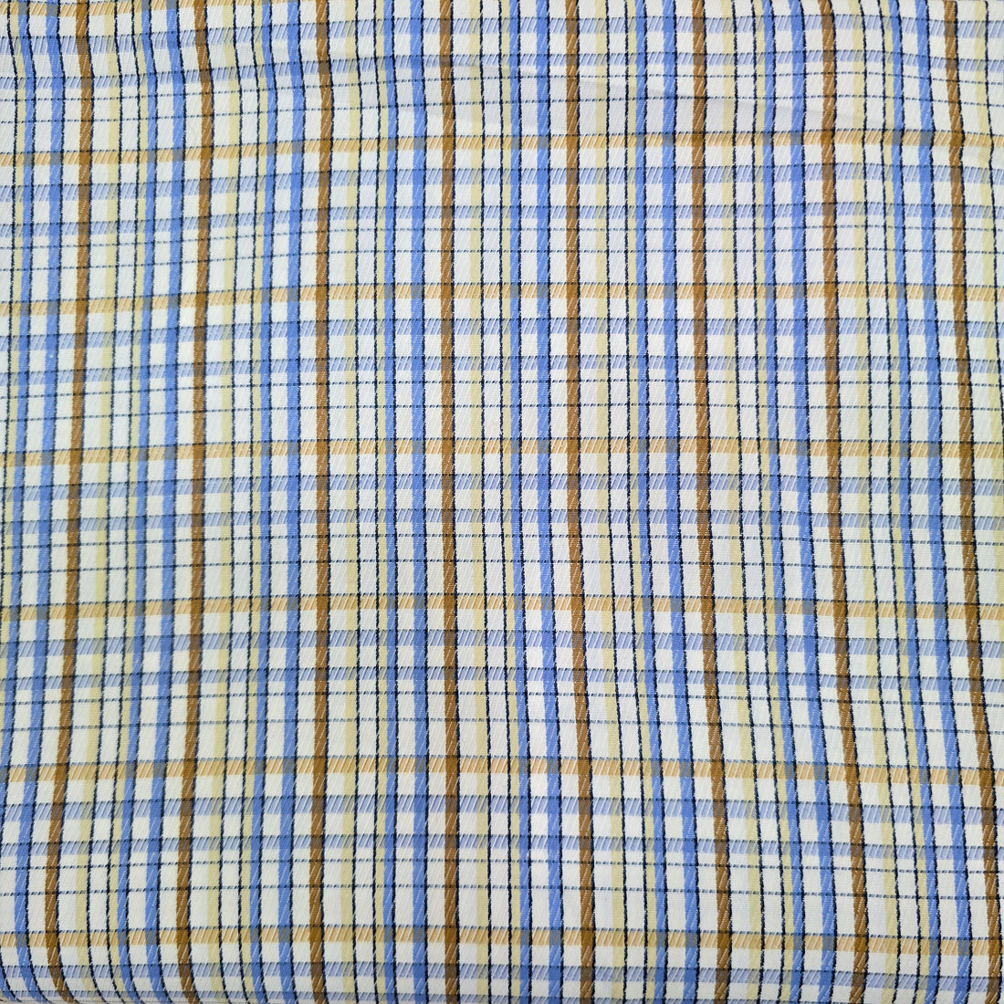 Close-up of plaid fabric with blue, brown, and beige colors.